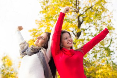 Young women standing,arms are spread open wide and her head is tilted back