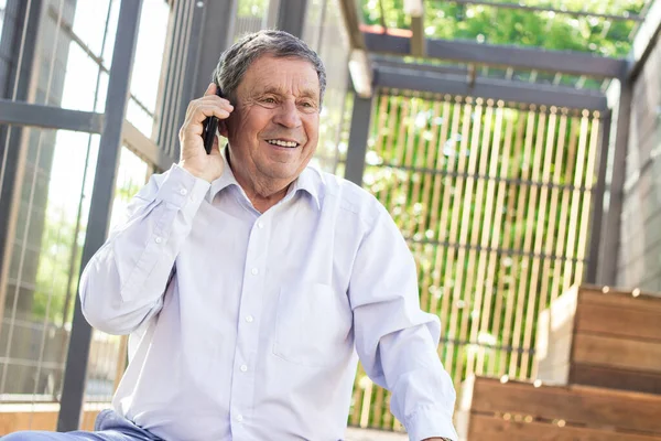 Smiling senior man talking on smartphone