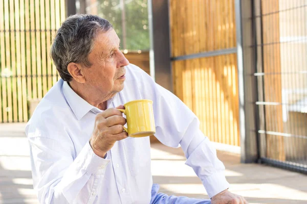 Thoughtful Senior Man Drinking Coffee Looking Away —  Fotos de Stock