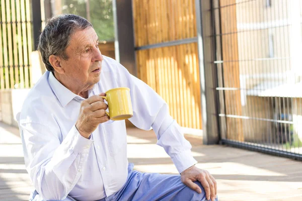 Thoughtful Senior Man Drinking Coffee Looking Away —  Fotos de Stock