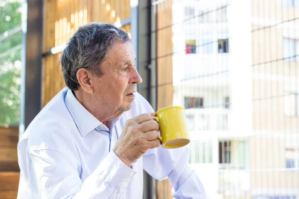 Thoughtful Senior Man Drinking Coffee Looking Away —  Fotos de Stock