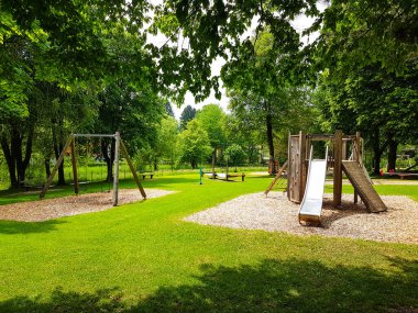 Mahalle parkı ve oyun alanı. Parktaki büyük ağacın altındaki çocuk parkı.