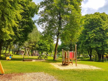 Mahalle parkı ve oyun alanı. Parktaki büyük ağacın altındaki çocuk parkı.