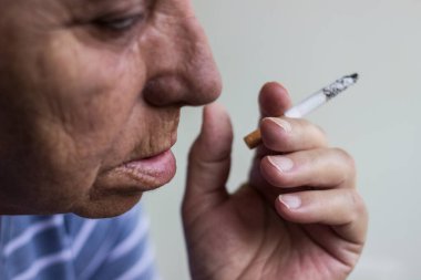 Olgun bir kadının portresi sigara içiyor.