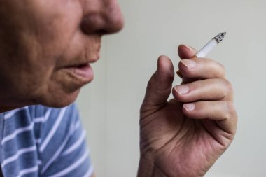 Olgun bir kadının portresi sigara içiyor.