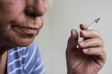 Olgun bir kadının portresi sigara içiyor.