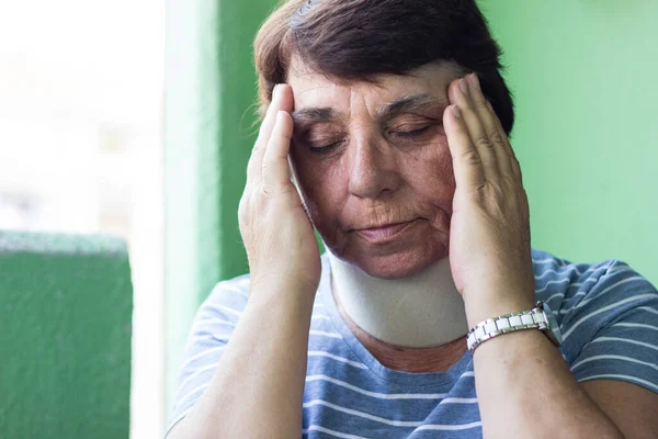 Senior woman with neck injury. Senior woman wearing neck brace