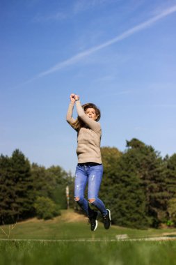 Doğada zıplayan mutlu kadın