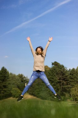 Doğada zıplayan mutlu kadın