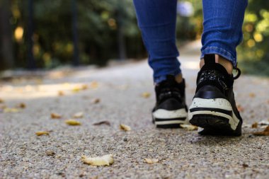 Doğada sonbahar yaprakları üzerinde yürümek