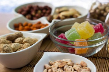 Sağlıklı yağ, protein yiyeceği ve atıştırmalık. Şam fıstığı, fındık, çam fıstığı, badem, balkabağı çekirdeği, ayçekirdeği, fıstık, kaju ve ceviz gibi fındık çeşitleriyle dolu Rustik ahşap masa.