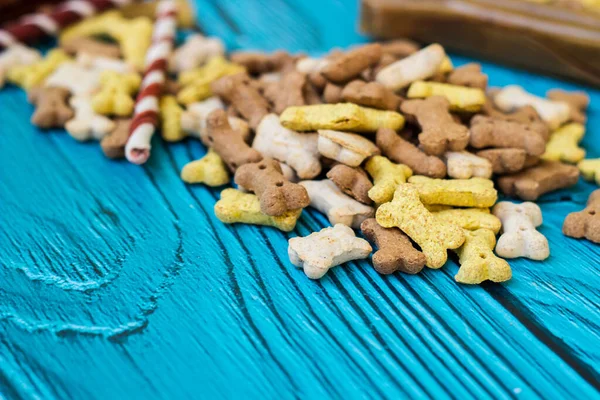 Dog bones and biscuits on turquoise wooden background