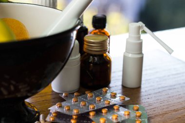 Geniş bir hap grubu, su toplayan paketler ve ilaç şişesi. Havan topu ve tokmak