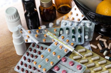 Geniş bir hap grubu, su toplayan paketler ve ilaç şişesi. Havan topu ve tokmak