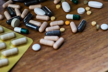 Ahşap zemin üzerinde çeşitli kapsüller, haplar ve kabarcıklar geniş bir grup arka plan