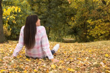Genç kadın çimlere uzanıyor.