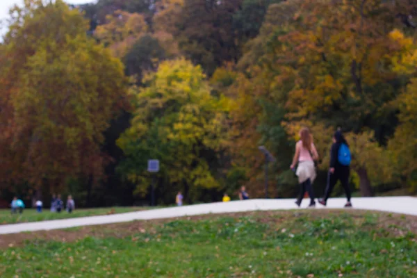 Defocused autumn park with people walking