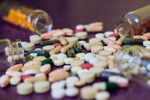 Tıbbi Şişeler Ilaç Hapları Mor Arka Plana Dökülüyor — Stok fotoğraf