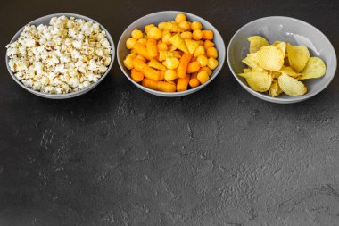 Koyu renkli masa üzerinde tuzlu abur cuburlar. Filmde patates cipsi, patlamış mısır, fıstık, peynir çubuğu, ketçap çubuğu, tzatziki cipsi, dumanlı fiske ve diğerleri yer alıyor.