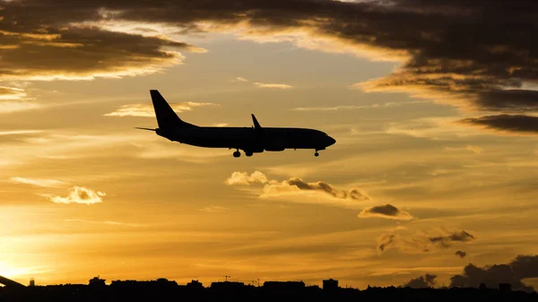 Ein Passagierflugzeug landet bei Sonnenuntergang. Hat das Fahrwerk abgesenkt — Stockfoto