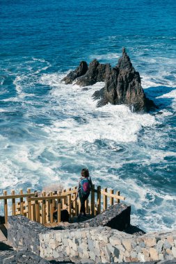Kadın bir uçurumun kenarında durmuş sahildeki dalgaları seyrederken görülmüş. Playa de Benijo, Tenerife 'de