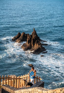 Genç mutlu çift köpekleriyle birlikte gün batımının tadını çıkarıyor.