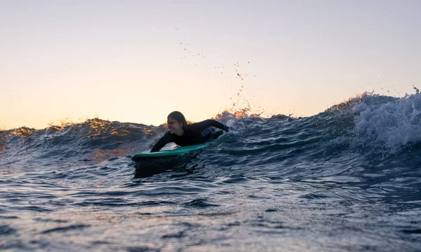 一个冲浪女孩在冲浪时的低角度图像 脚踏在水里的木板上 高质量的照片 — 图库照片