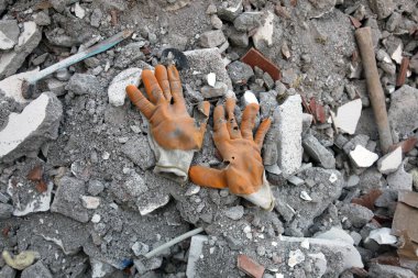 İnşaat molozu ya da atık üzerinde iş eldiveni giyiyor. Çalışkandır. Üst görünüm.