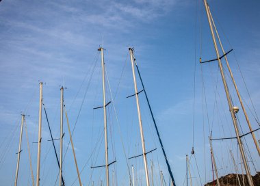 Yat limanında yelken direkleri var. Mavi gökyüzü olan gemi direği.
