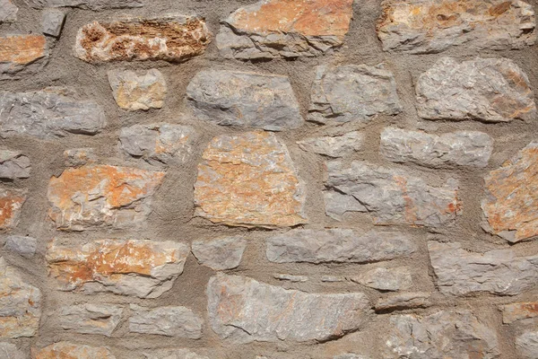 Πέτρινος Τοίχος Είναι Κατασκευασμένος Από Ανοιχτόχρωμες Πορτοκαλί Και Γκρι Πέτρες — Φωτογραφία Αρχείου