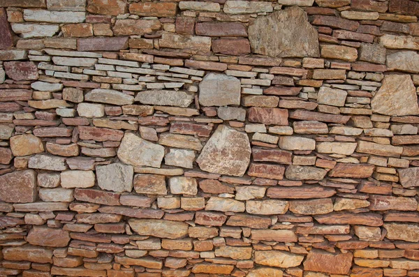 一个不同的石墙是由不同大小的石头制成的 非对称石墙 — 图库照片