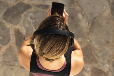 Eğitimden sonra akıllı telefona bakan genç bir kadın.