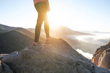 Tanınmayan bir kadın gün batımında yürüyüşe çıkıyor.