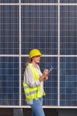 Mühendis kadın güneş panellerini test ediyor.