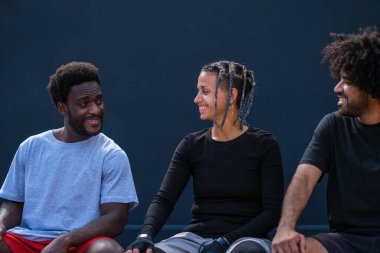 Kentsel yaşam tarzına sahip üç genç birlikte gülüyor.