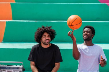 Afro stili olan iki genç adam birlikte zaman geçiriyorlar.