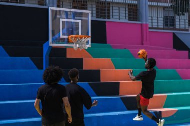 Sokak sahalarında basketbol oynayan bir grup zenci.