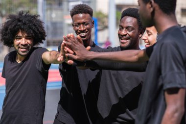 Bir grup arkadaş takım olarak el ele tutuşuyorlar.