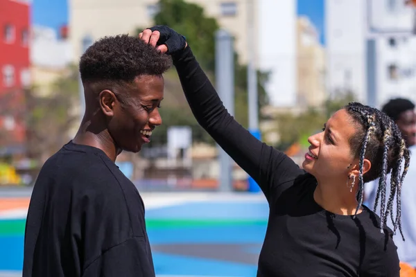 Örgülü kadın genç arkadaşının saç stilini kontrol ediyor.