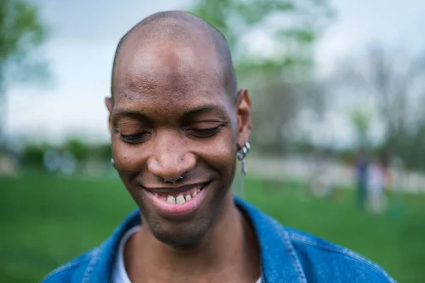 Portrait of non-binary man with eyes closed and smiling