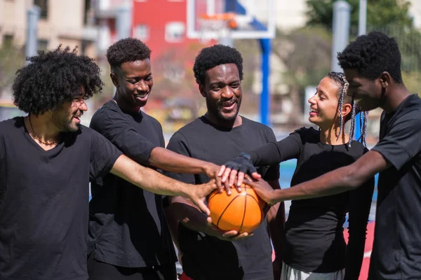 Group of friends united to play basketball on colored court