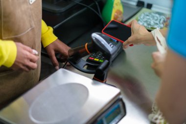 Yerel mağazada cep telefonuyla ödeme yapan tanınmayan kişi