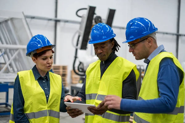 Three co-workers interacting to improve the operation of the factory