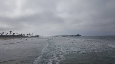 California shore - beautiful waves splashing against the pier