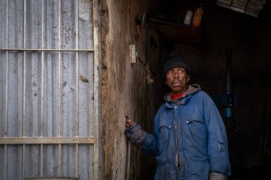 A tyre shop worker emerges from his workshop in Grahamstown, South Africa