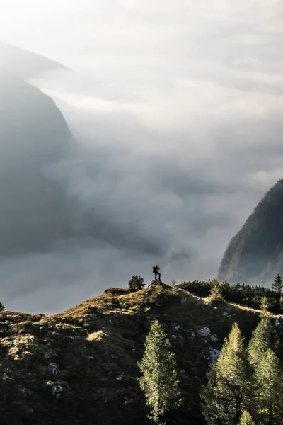 hiker with camera at panorama view in impressive mountains during sunrise