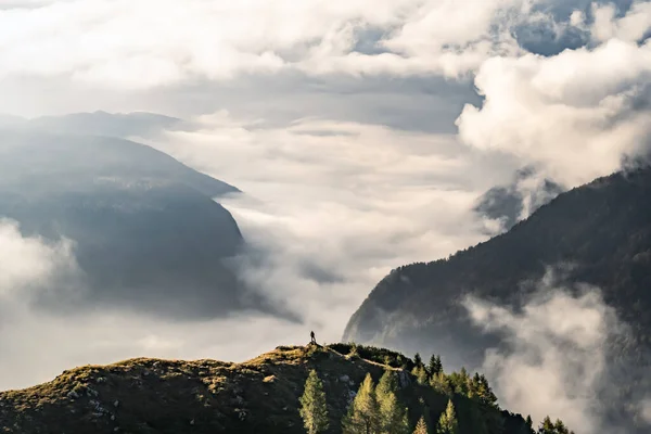hiker with panorama view in impressive mountains during sunrise