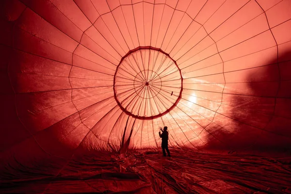 prepare ropes inside illuminated red hot-air balloon