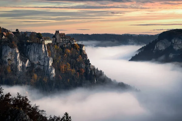 castle above fog in Danube river valley in Germany during sunrise