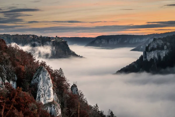 castle above fog in Danube river valley in Germany during sunrise